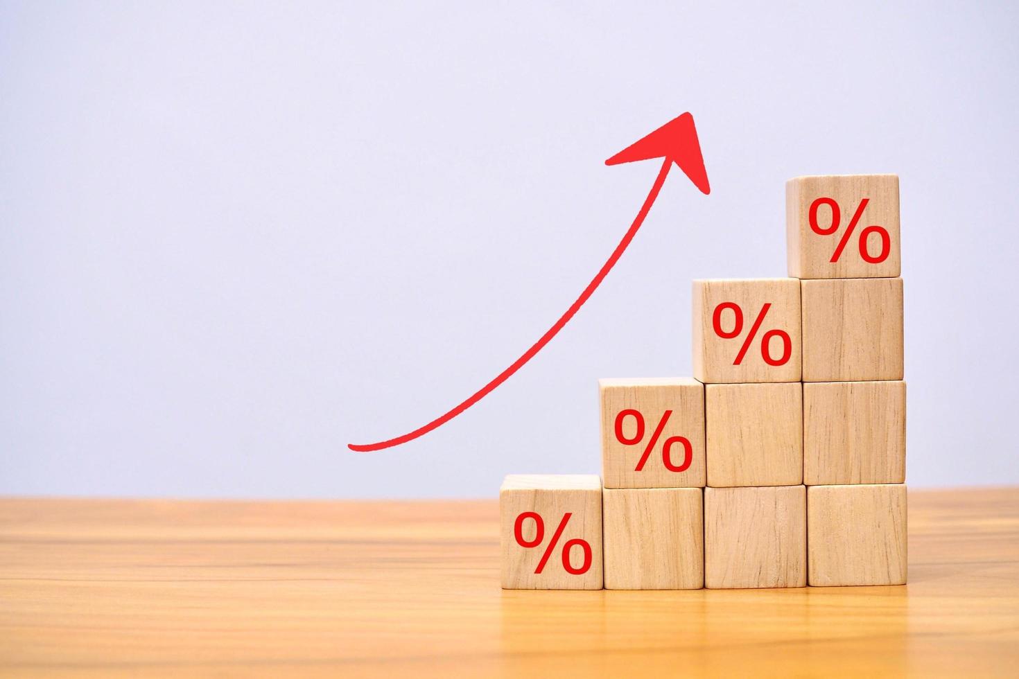 flecha hacia arriba de elementos de bloque de madera con concepto de signo de porcentaje de economía. foto