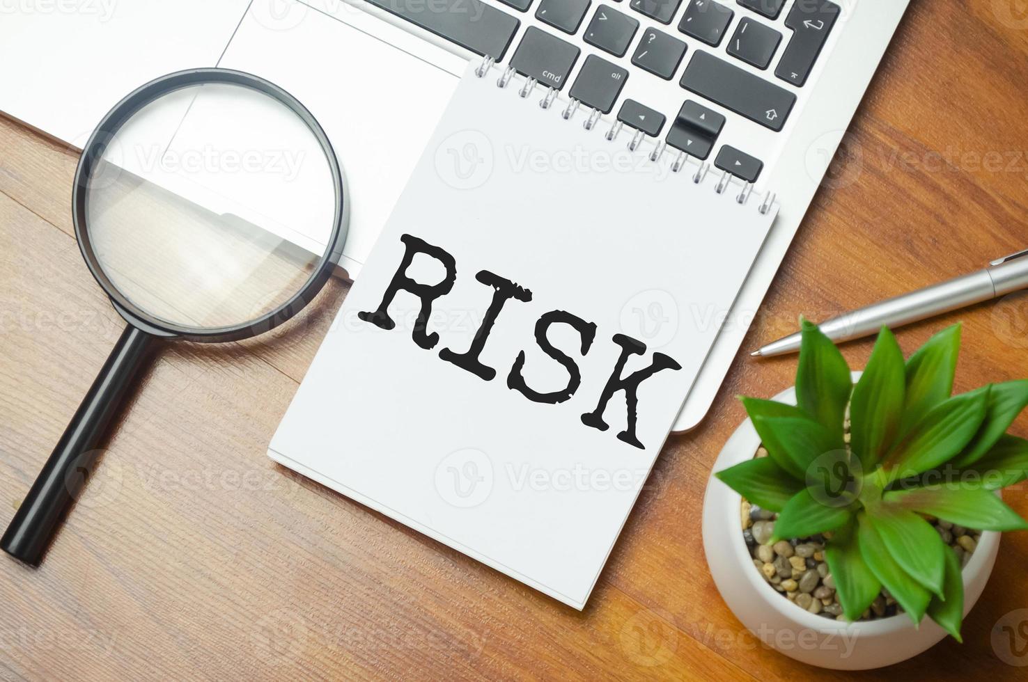 RISK words in a white notepad on the background of a laptop photo