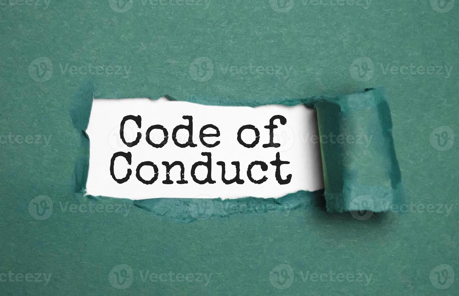 The text Code of conduct appearing behind torn brown paper photo