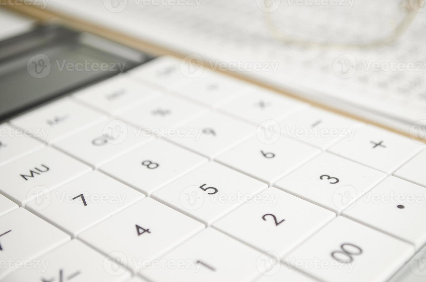 financial report, pen with cap, calculator, glasses and paper photo