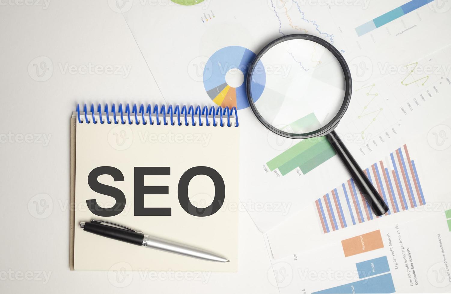 Office wooden table with a notebook SEO and magnifier photo