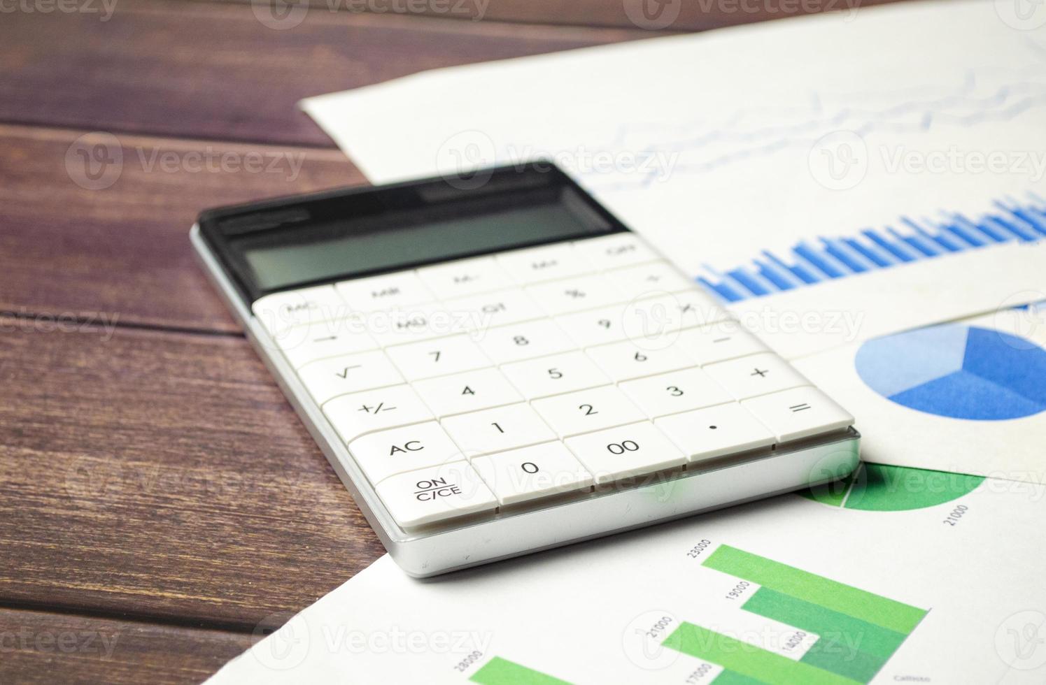 Work space business finance office concept on brown wooden table desk with calculator and graph document photo