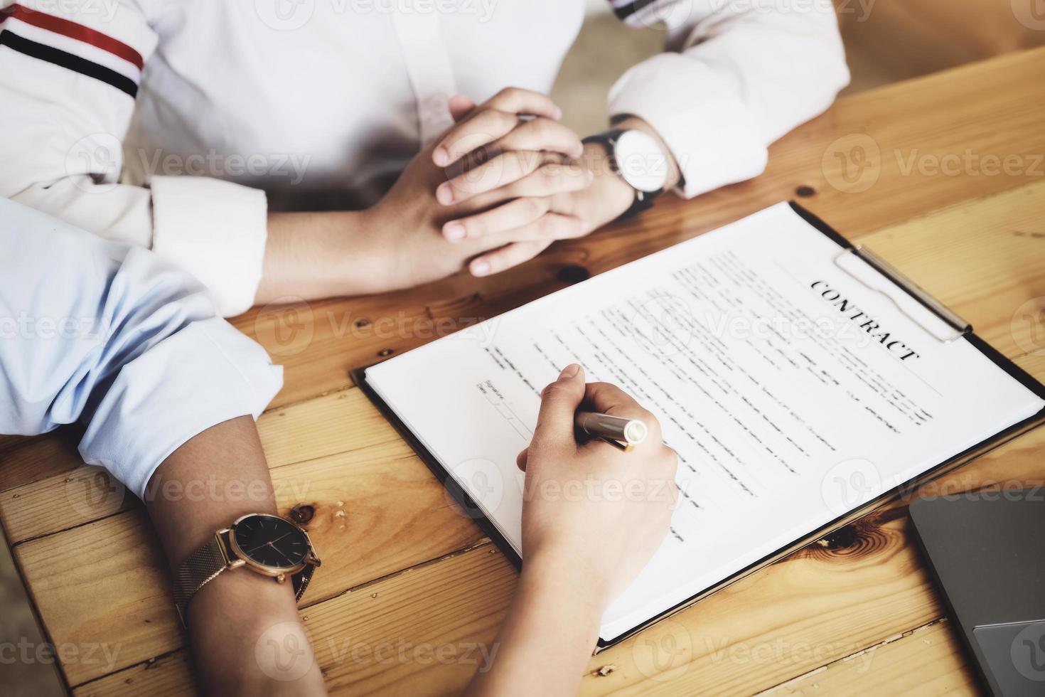 Business owner holding a pen to read the conditions to enter into a joint venture contract with a partner company. photo