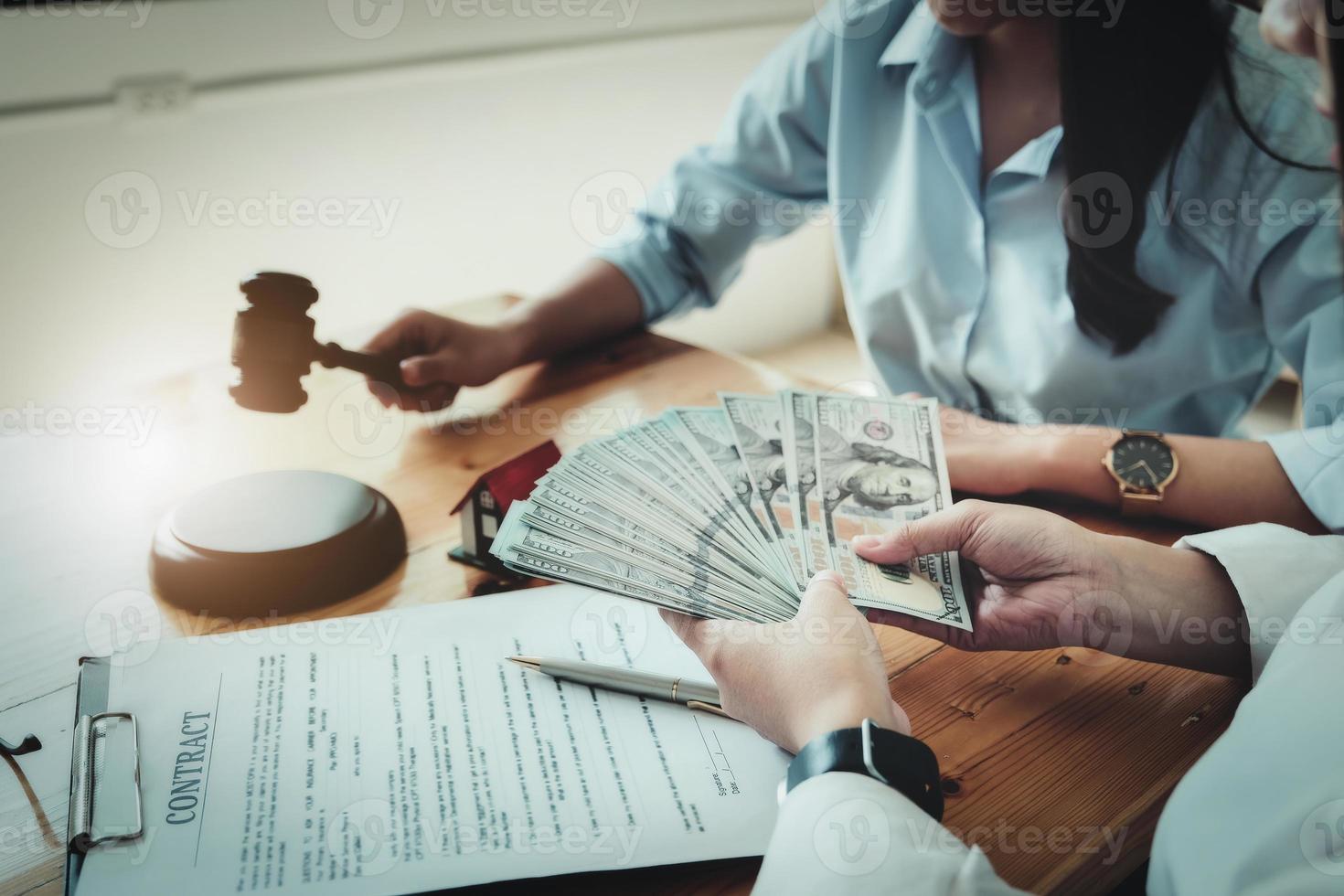 Legal concepts and contracts It focuses on women holding dollars with  contract documents and home purchase payments. photo