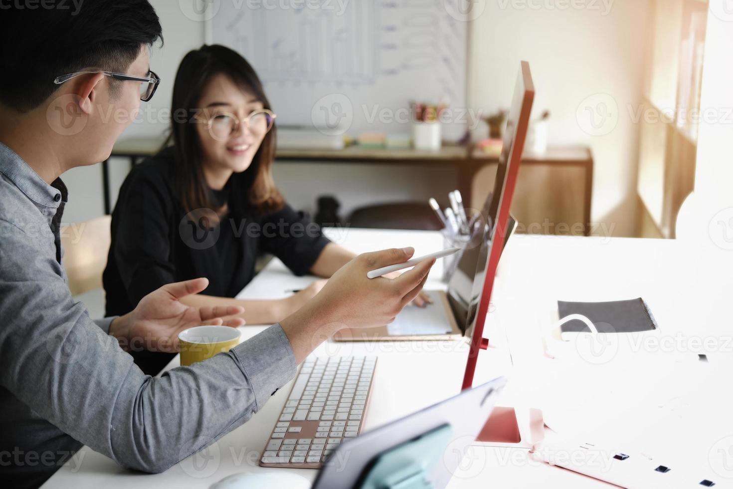 An investment expert points a pen at a computer monitor to analyze the stock market to teach you how to make a profit. photo