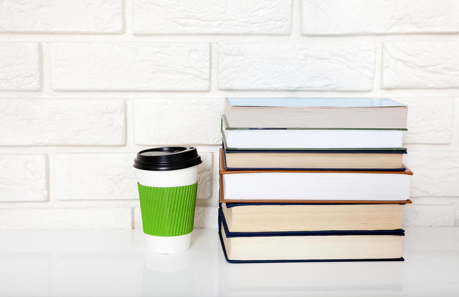 Education literature. Cup of coffee and books on the table in a class. Top view and copy space. Selective focus photo