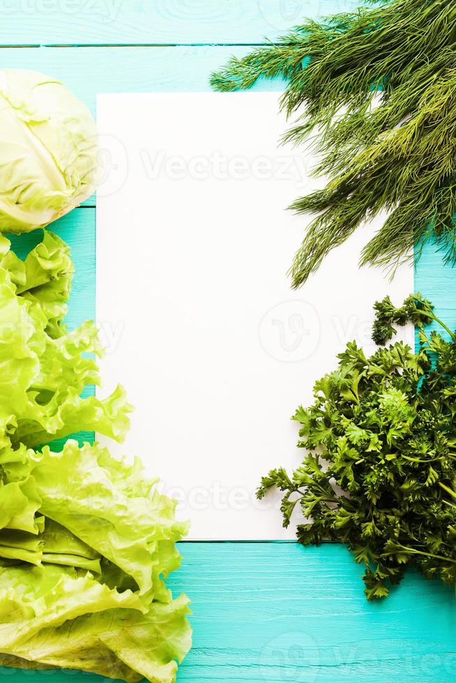 Different vegetables on kitchen table with recipe list and copy space. Top view photo