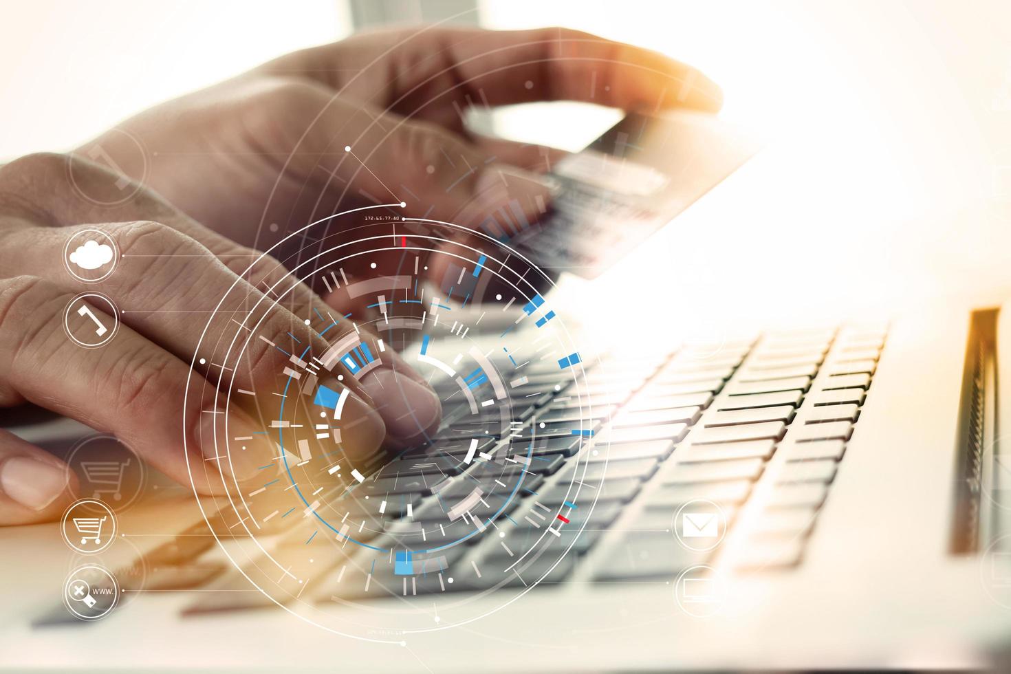 Close up of Hand using credit card and laptop computer on wooden desk with VR icon chart graph diagram photo