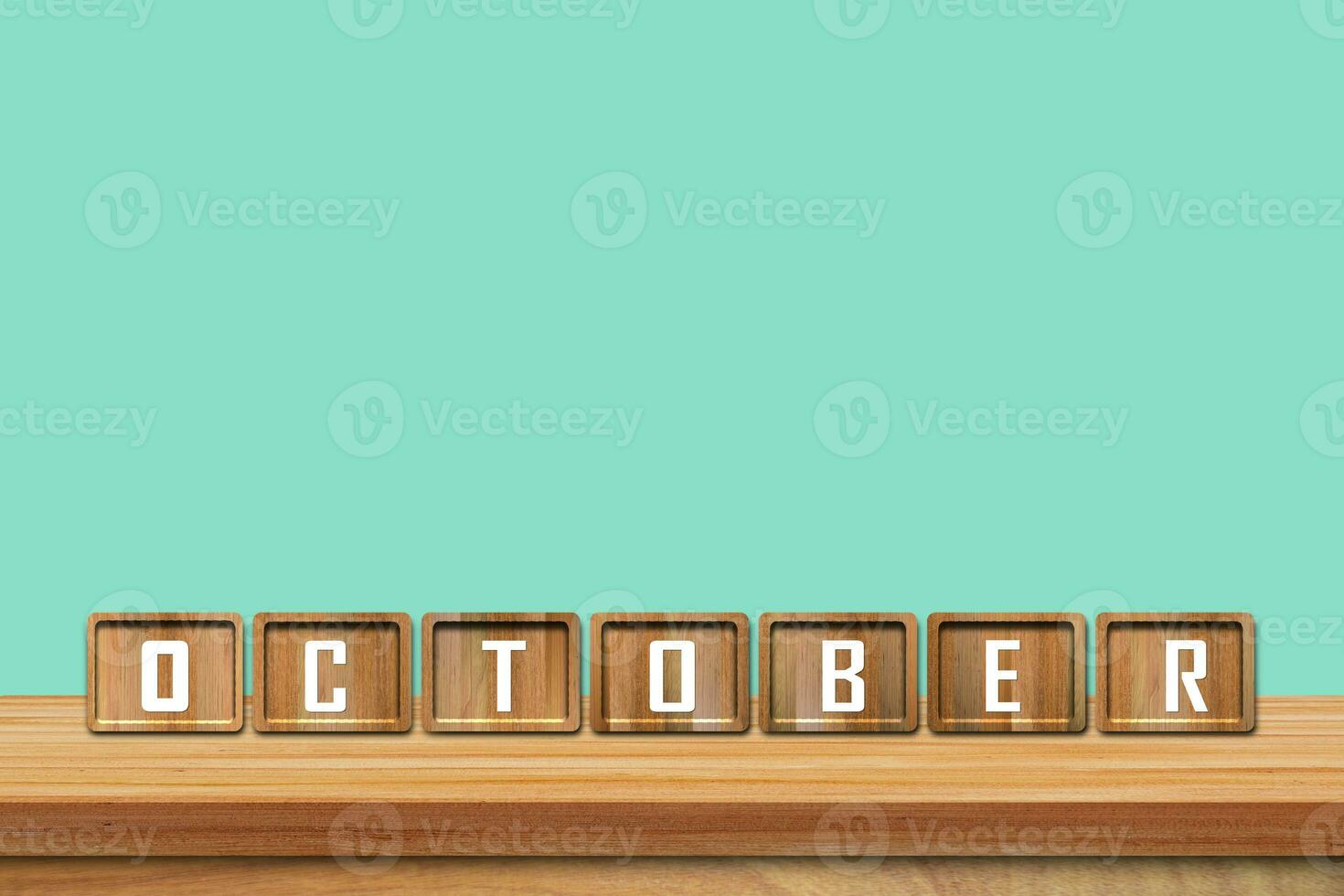 October alphabet blocks on wooden table with blue background. Copy space for text photo