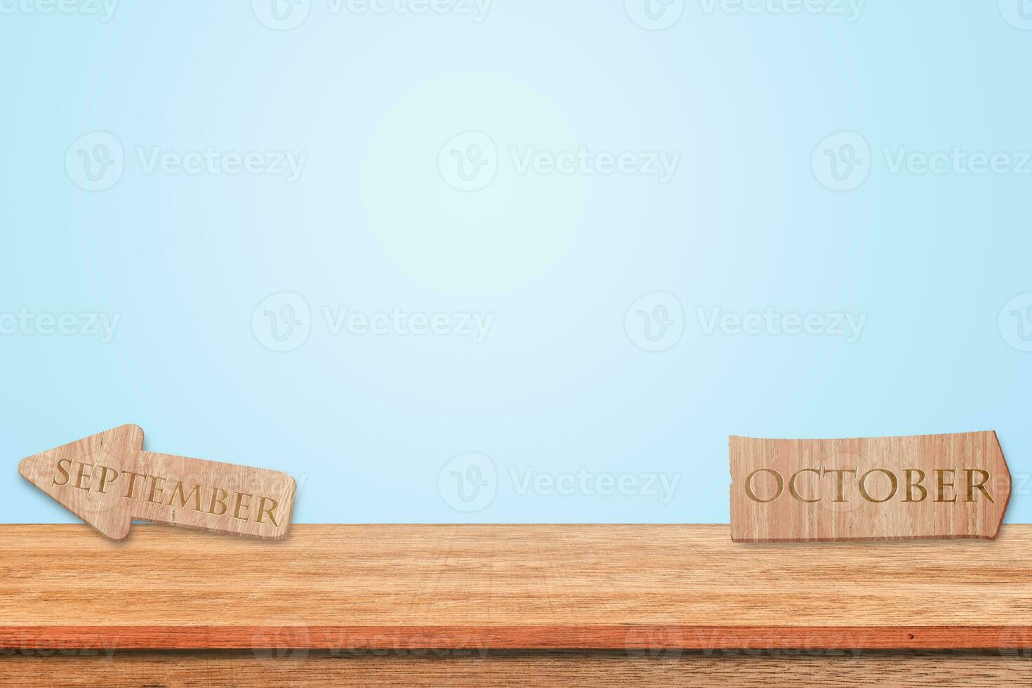 alfabeto de signos de madera septiembre y octubre puesto sobre la mesa de madera con fondo azul. copie el espacio para el texto. foto