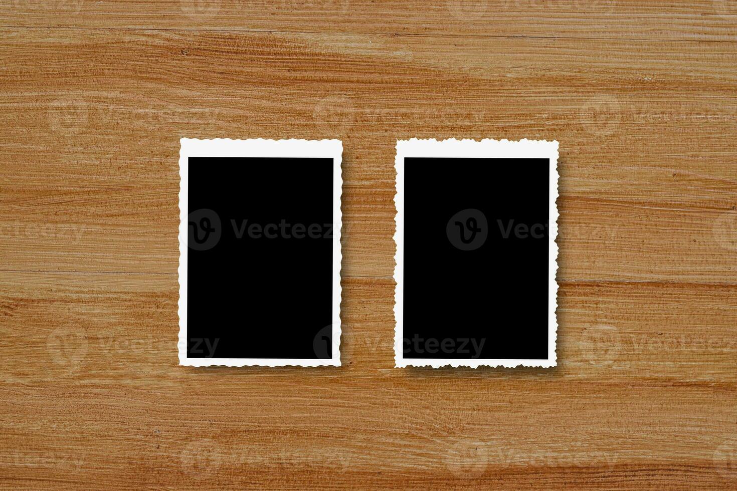 Top view of blank photo frames on wooden table background.