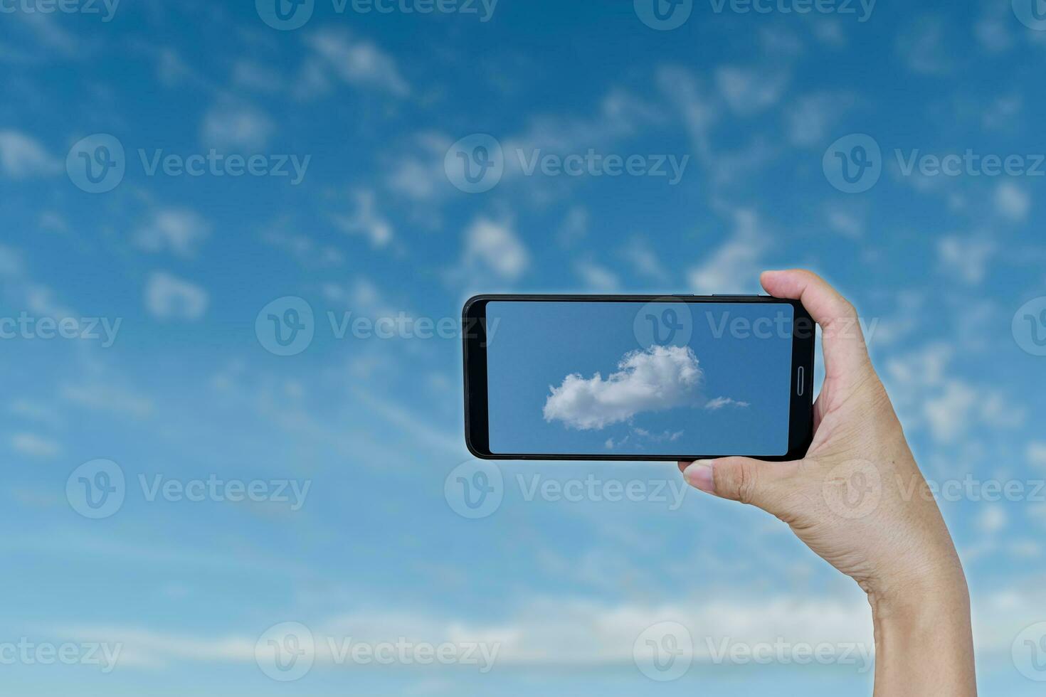 Hand holding smartphone for recording take photo a cloud shape is helicopter on blue sky.