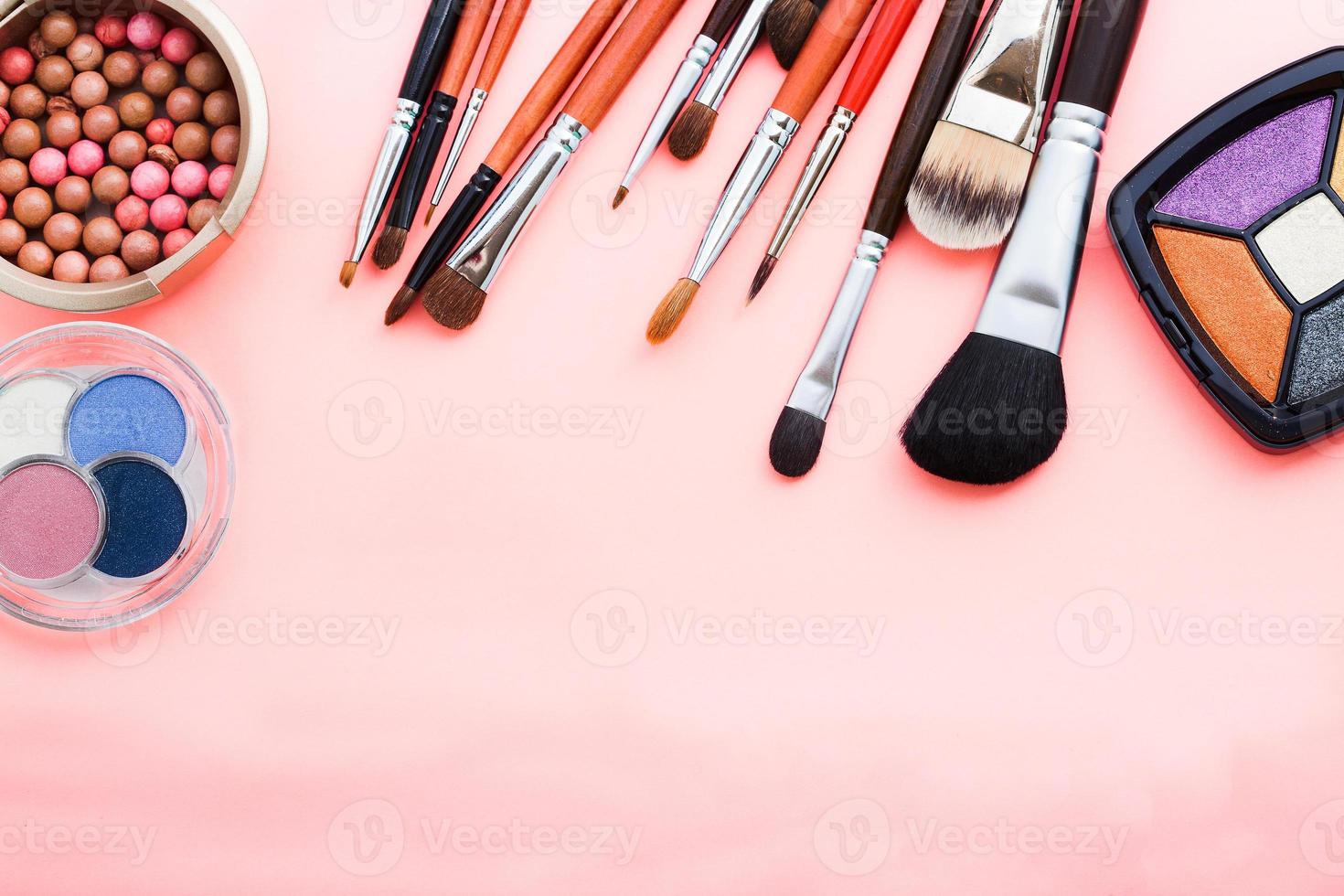 Frame of cosmetic accessories on pink background with copy space. Top view photo