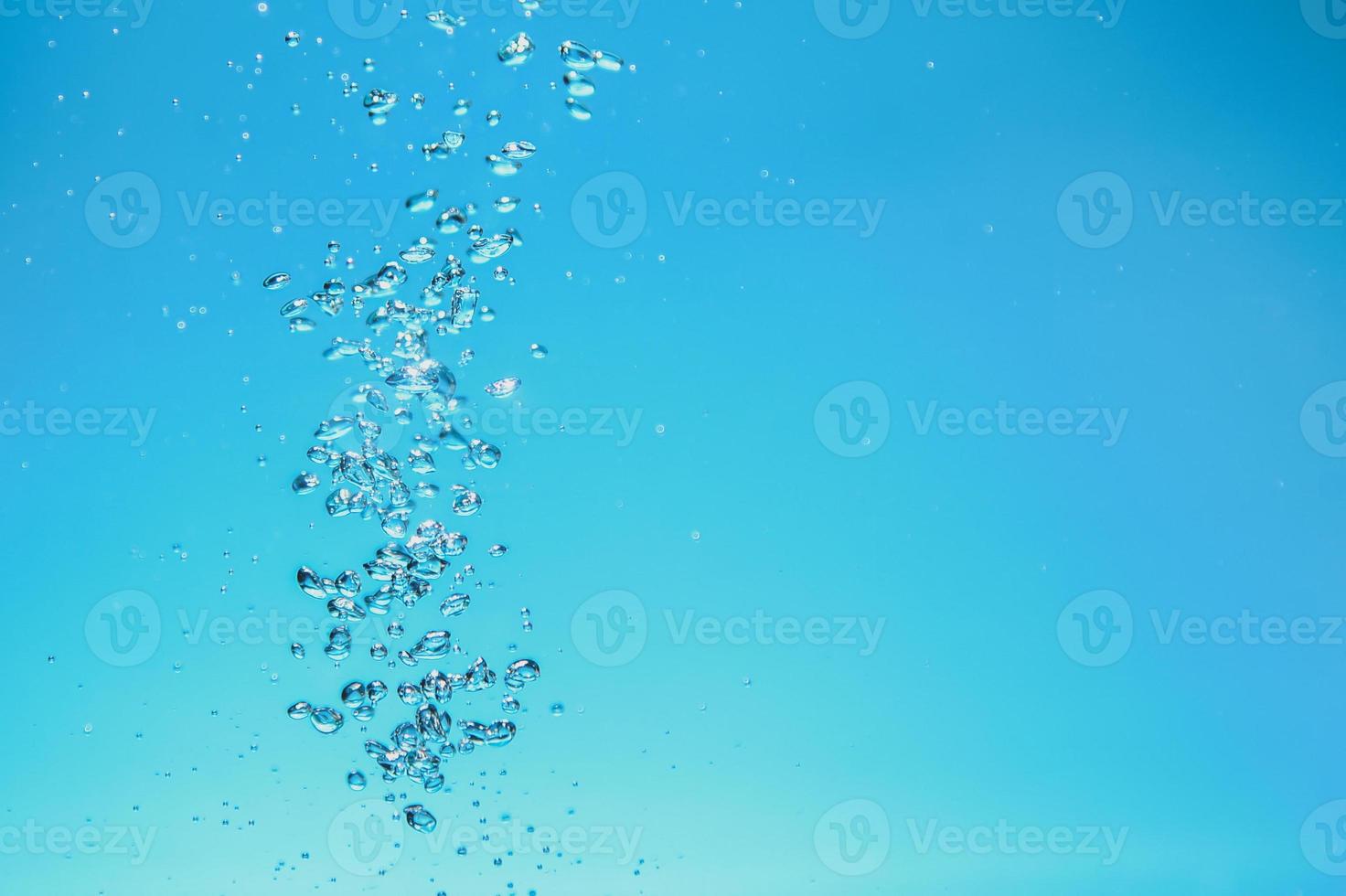 Abstract background image of bubbles in water. Clean water with water droplets and waves. Fresh water a glass with bubbles blue background. photo