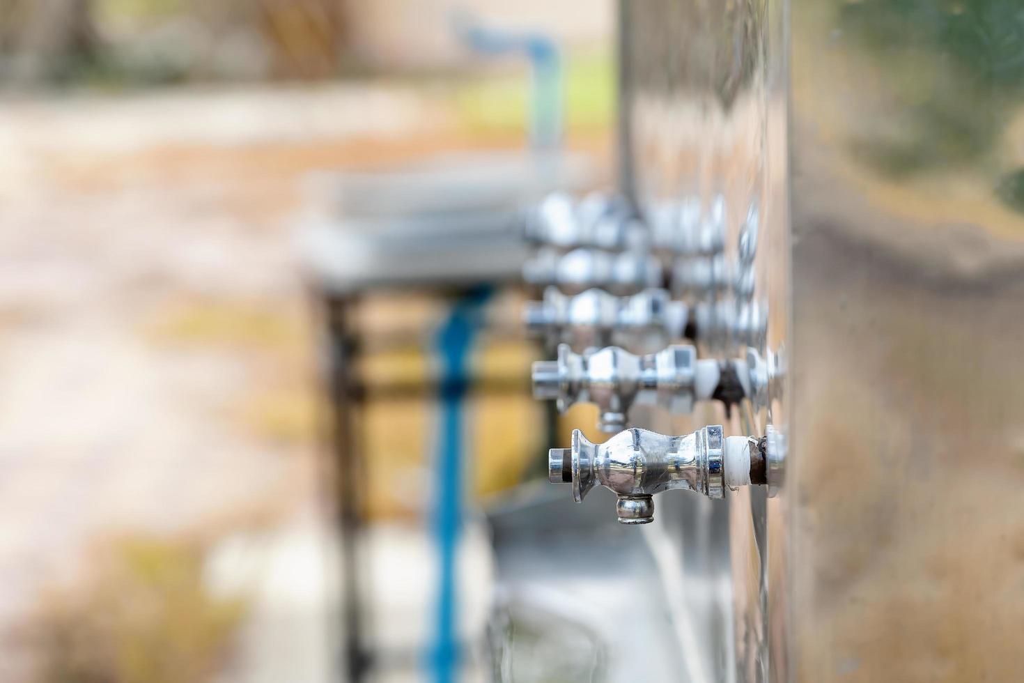 Close up of drinking faucets attached to the drinking water dispenser, Stainless steel drinking water faucets. Selective focus on first cooler faucets with copy space. Healthy drinking concept. photo