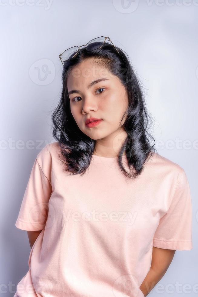 Close up portrait of gorgeous Asian woman casual t-shirt standing and looking at camera with confidence isolated on white background in studio photo