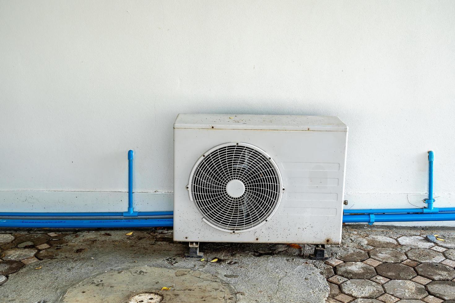 Close-up of external split wall type of outdoor home air conditioner unit installed on the outside building. Concepts of cool or heat or hot and air conditioning system maintenance. photo