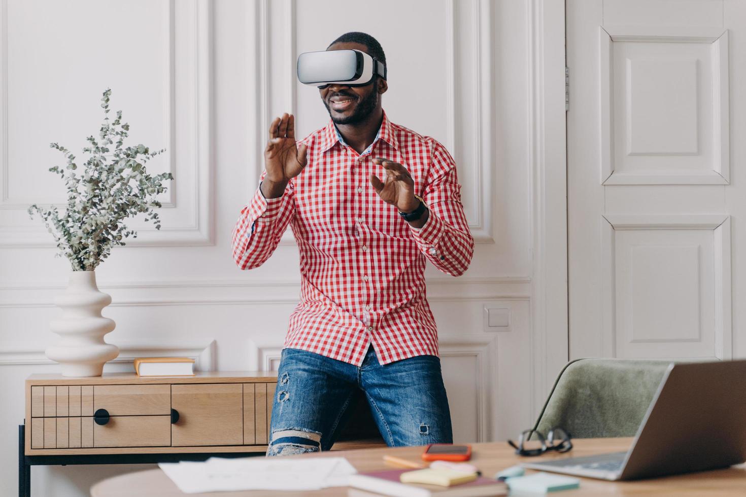 African man in VR headset interacting with digital interface, using innovative device for business photo