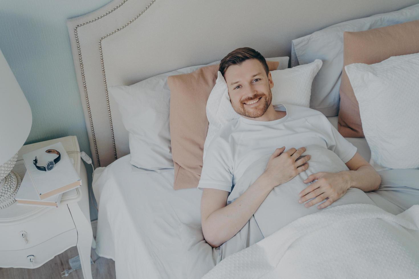 joven bien descansado despertando por la mañana en casa foto