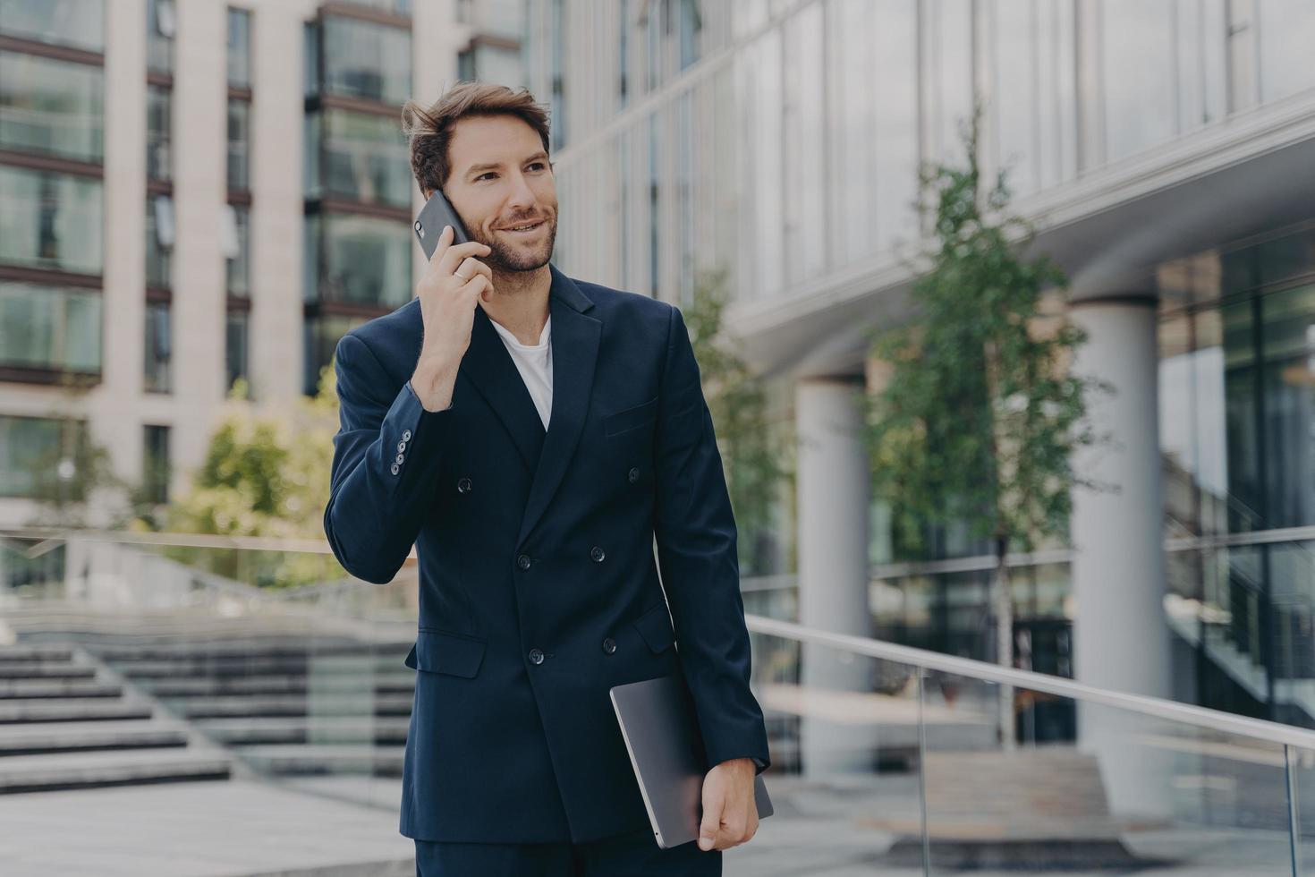 Handsome unshaven male entrepreneur communicates distantly with colleagues or partner photo