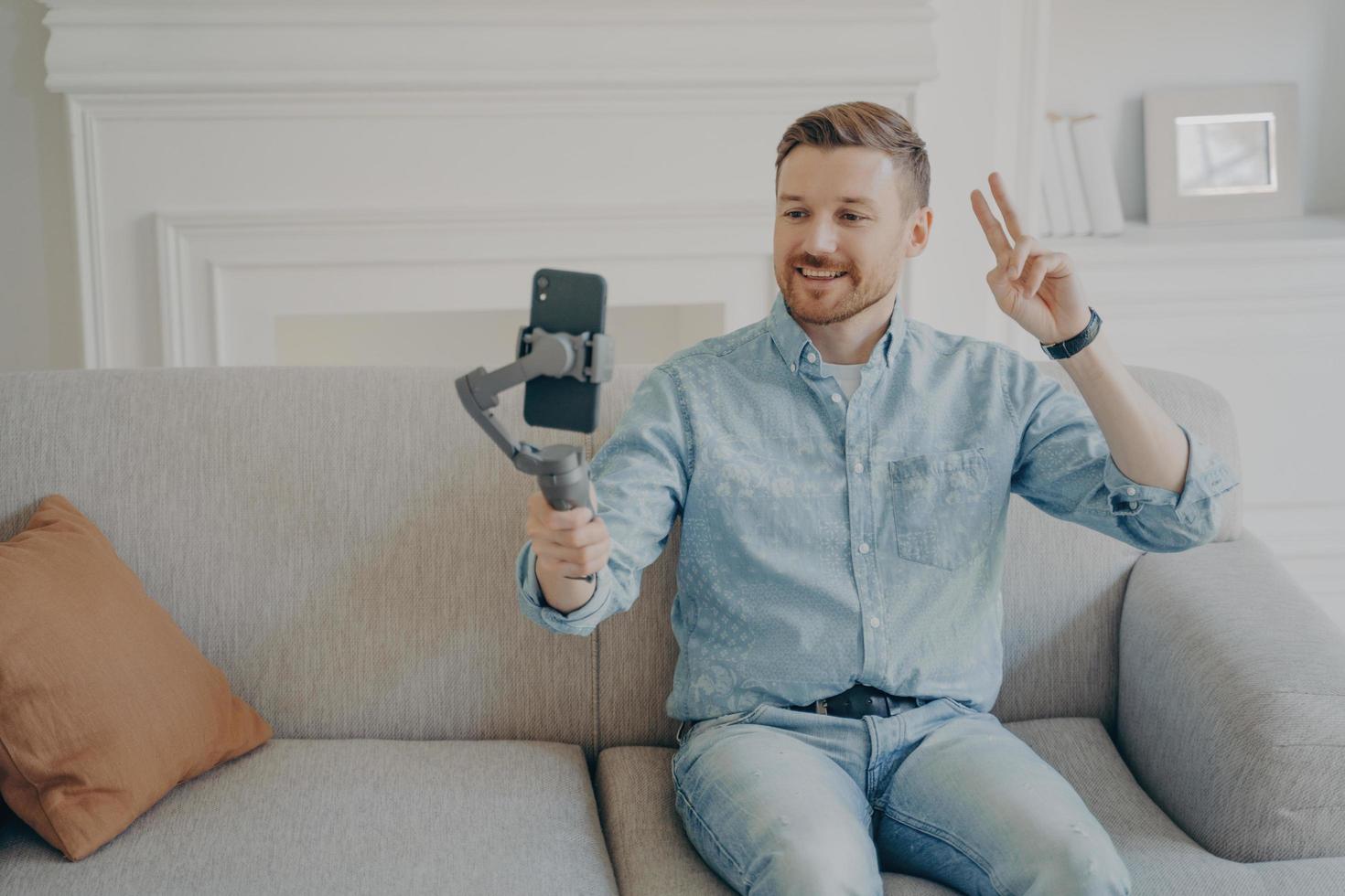 Young man showing peace gesture while video chatting photo