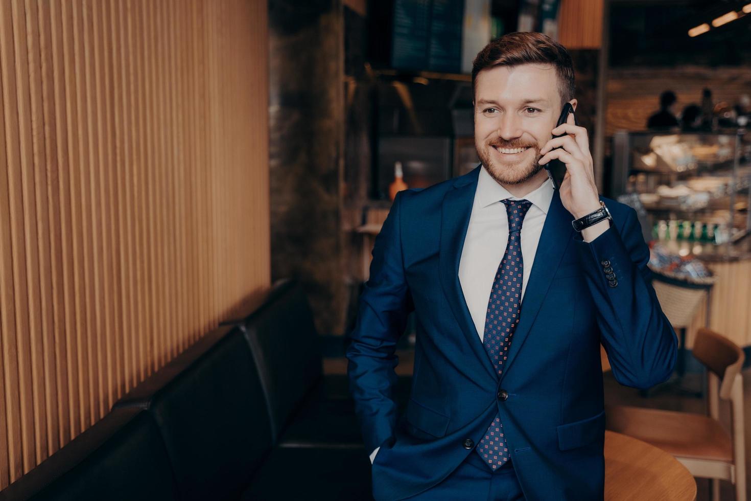 Well groomed bearded skilled banker in blazer suit talking on cellphone photo