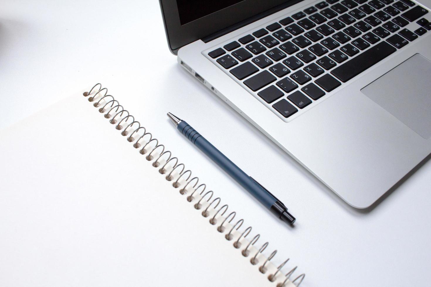notebook on white table with gadgets and decorations, top view of writer, freelancer or buisinessman work place photo