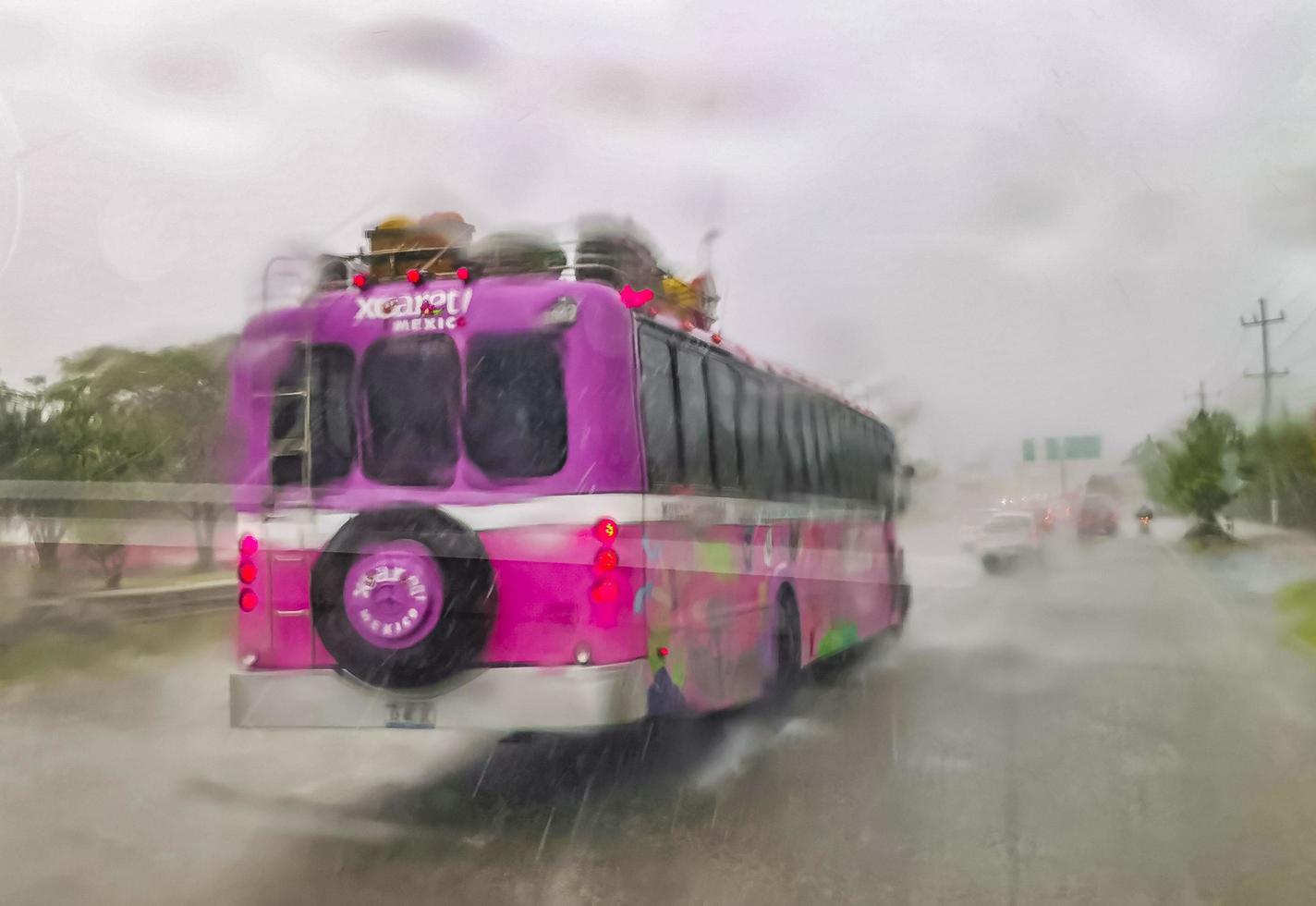 playa del carmen quintana roo méxico 2022 el autobús rosa xcaret conduce bajo fuertes lluvias en la autopista méxico. foto