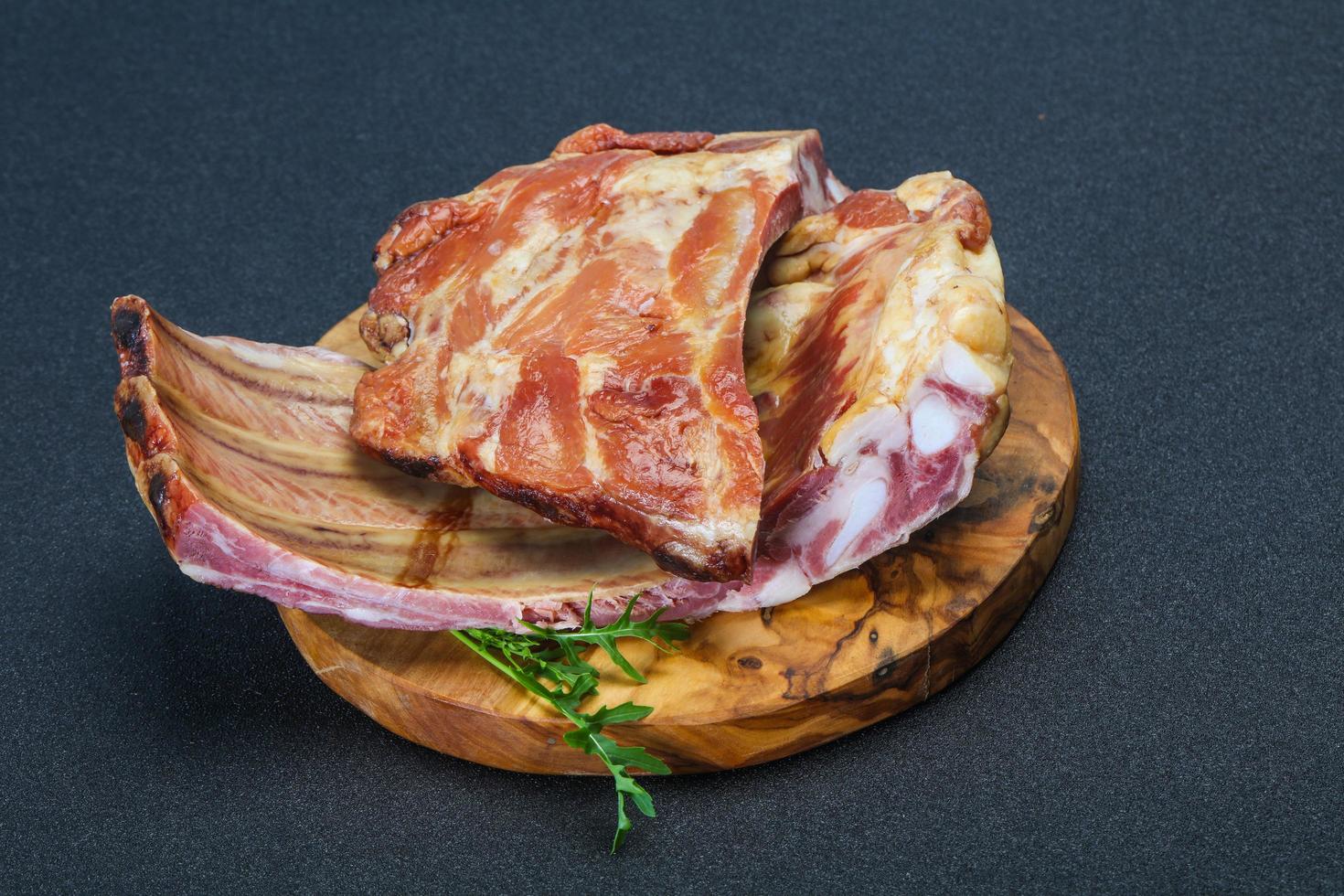 Smoked pork ribs over the wooden background photo