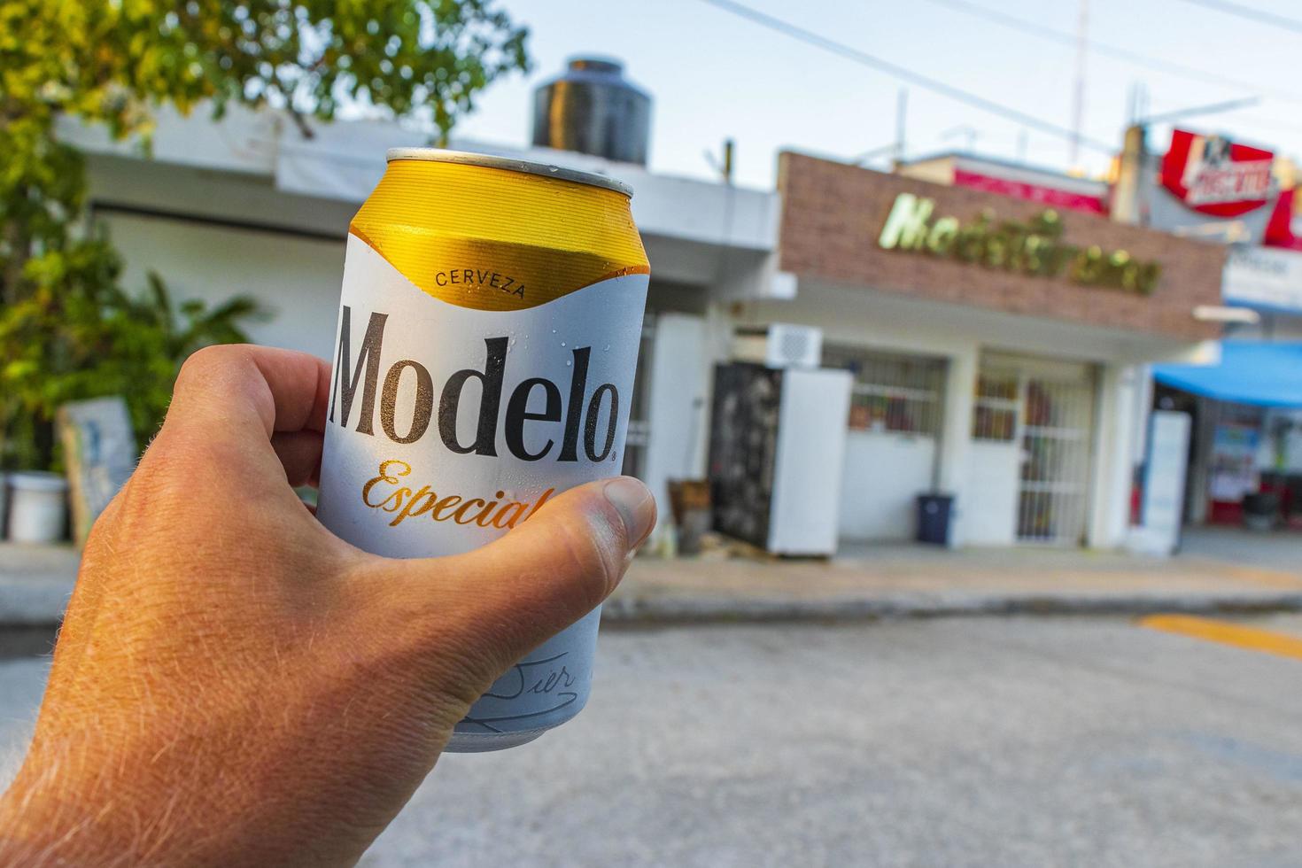 Chemuyil Roo Mexico 2022 Modelo beer can in the hand at store Chemuyil Mexico. photo