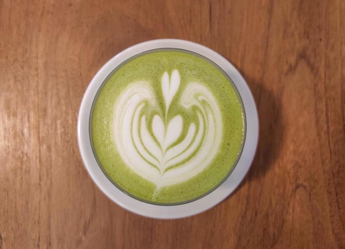 Top view of matcha latte on wooden background. photo