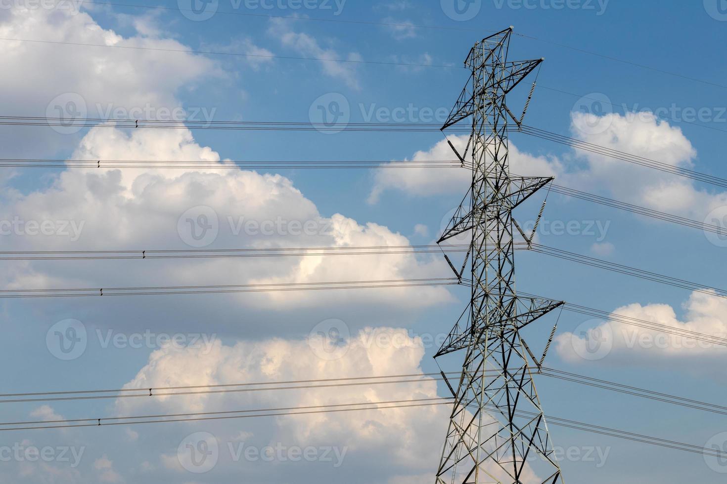 poste de alto voltaje con nubes y cielo. foto