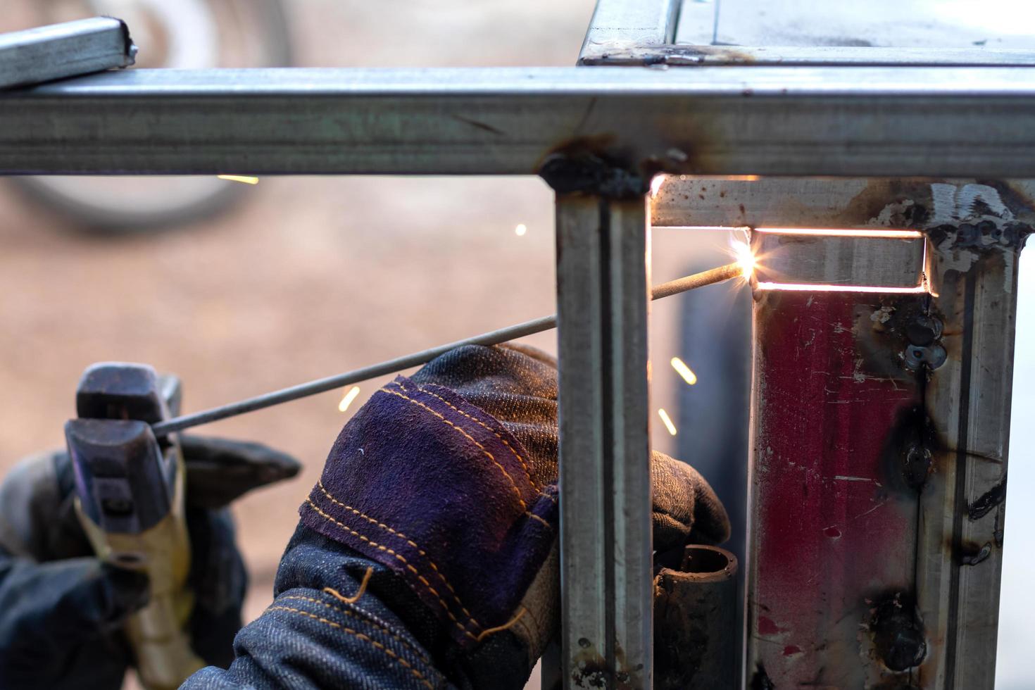 Close-up of a worker wearing gloves, welding metal. photo