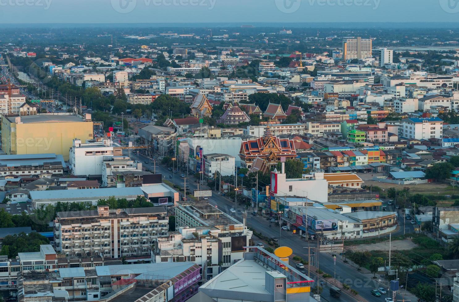 una vista desde lo alto de los numerosos edificios que albergan el tráfico de automóviles en las carreteras de una de las capitales provinciales de tailandia durante la hermosa puesta de sol al atardecer. foto