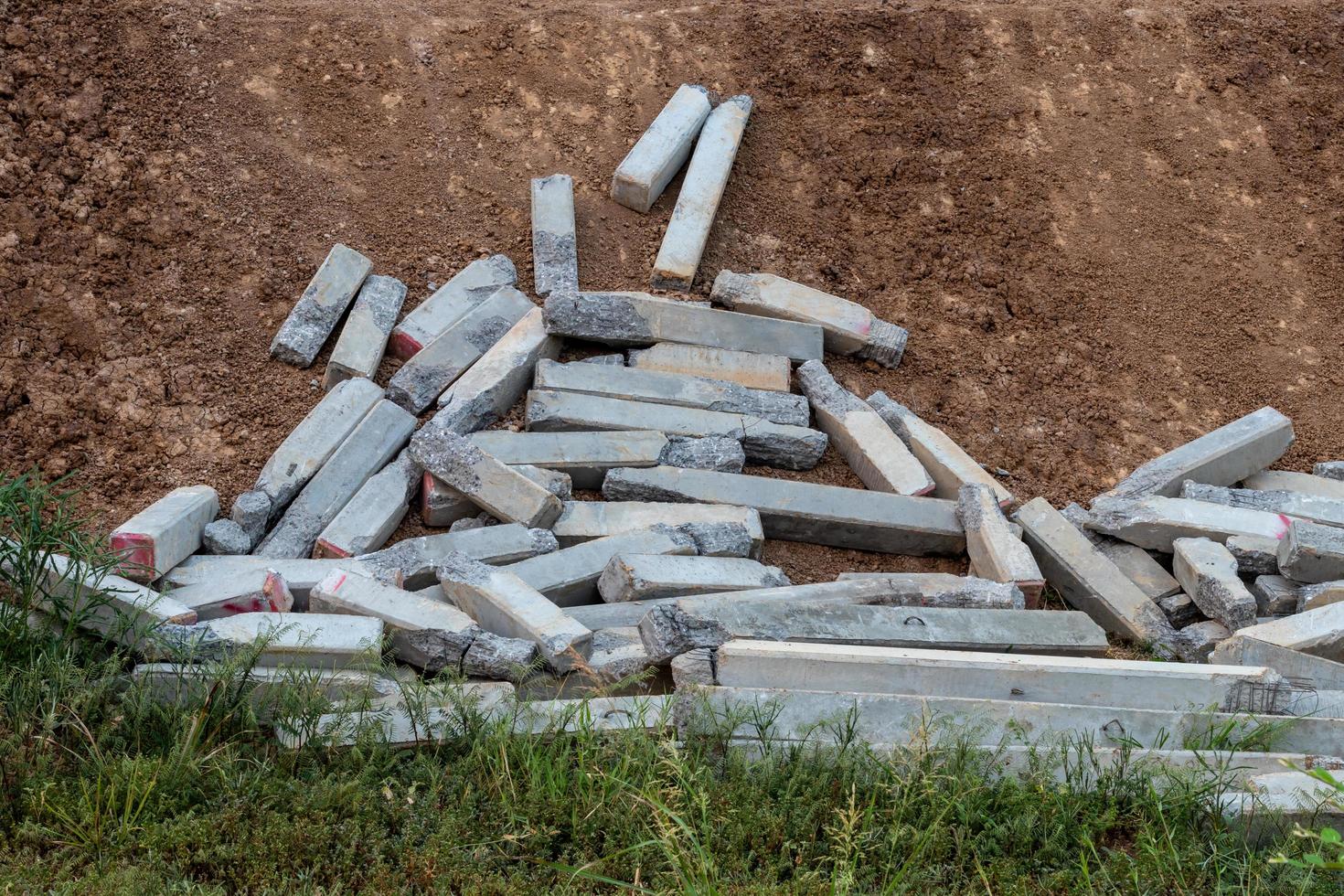 Concrete cement pillars fell on the ground slopes. photo