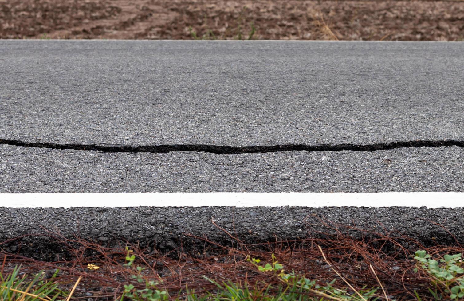 Asphalt road surface cracks near the white line. photo