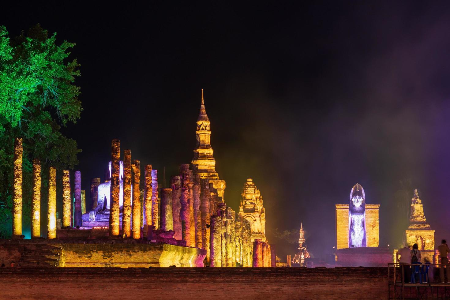 Old Buddhist temple at night with lights and smoke. photo