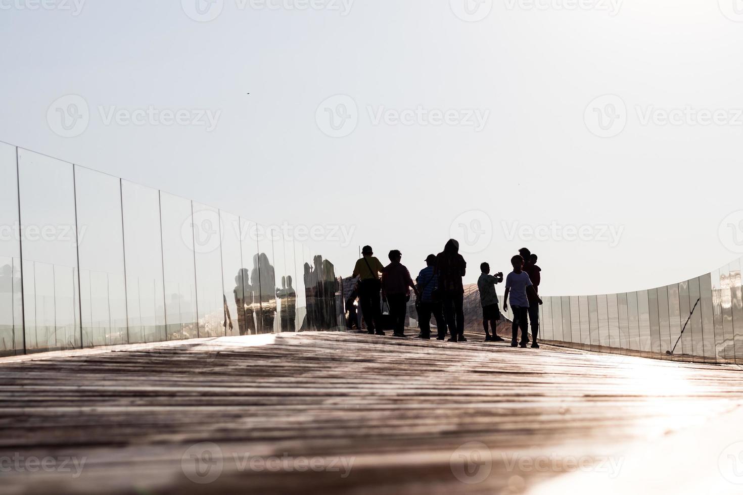 silueta de personas en el viejo puente de madera. foto