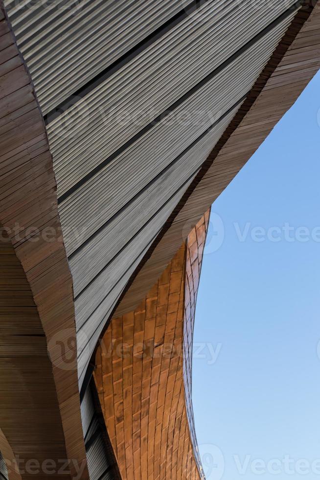 Low angle view, close-up, brown arched contemporary building exterior structure, abstract shape, distorted curves, a tourist attraction in a province of Thailand. photo