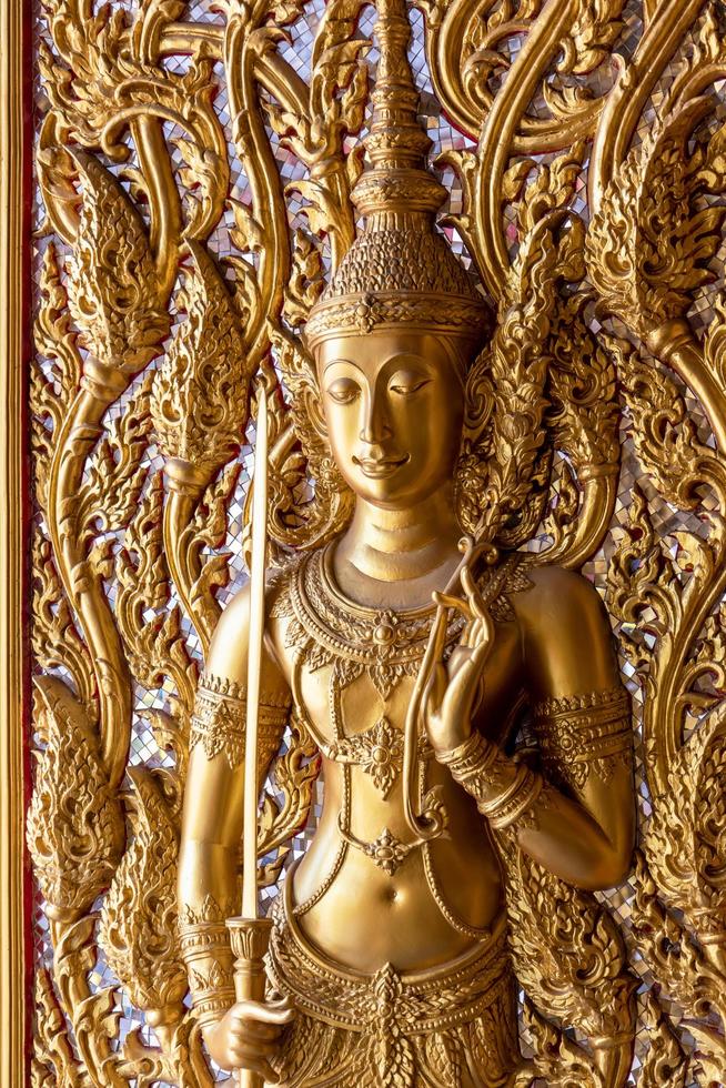 Golden angel statue on the temple door. photo