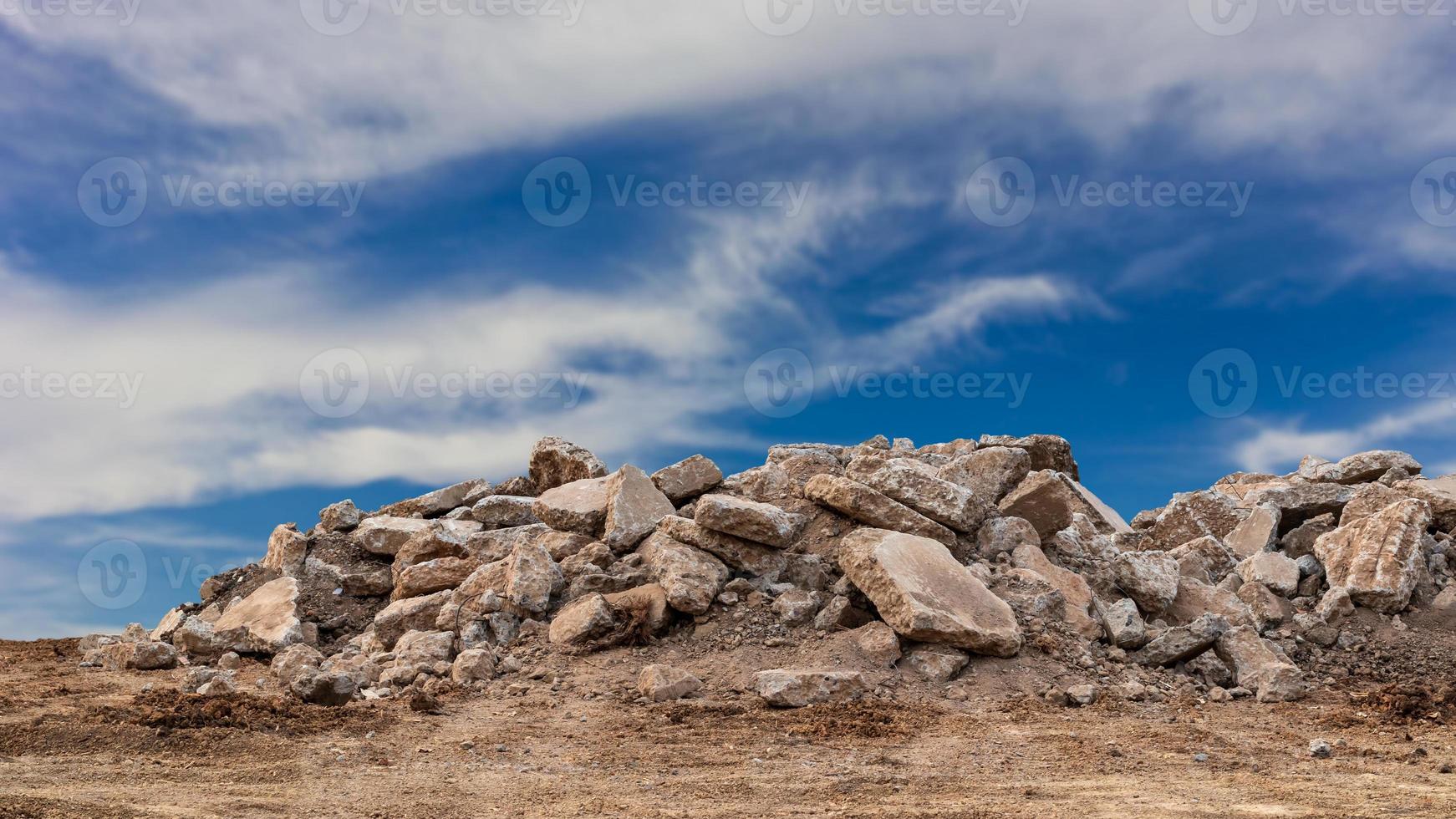 Concrete debris pile with cloudy sky in the background. photo