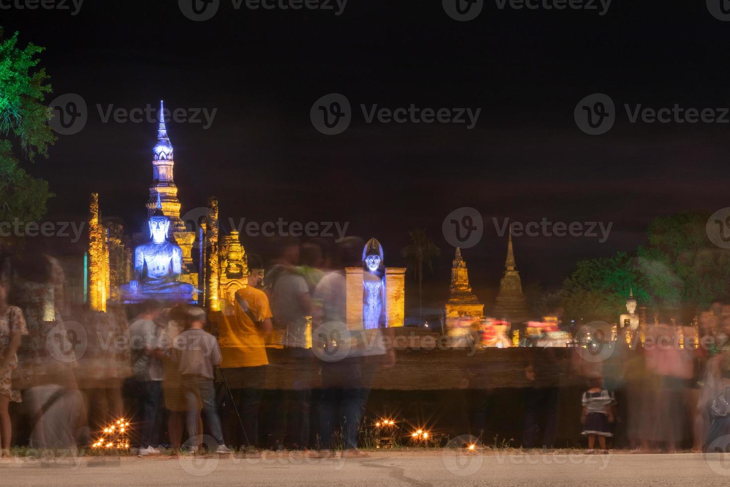 Old Buddhist architecture and people blurred at night. photo
