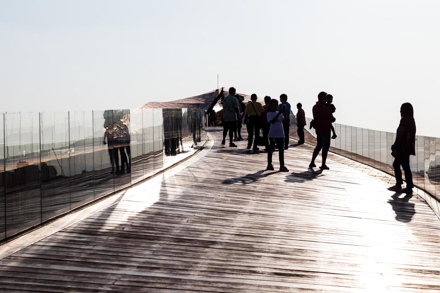 silueta de personas en el viejo puente de madera. foto