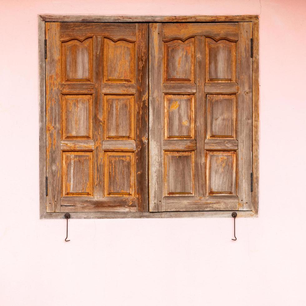 Old wooden windows with pink concrete walls. photo