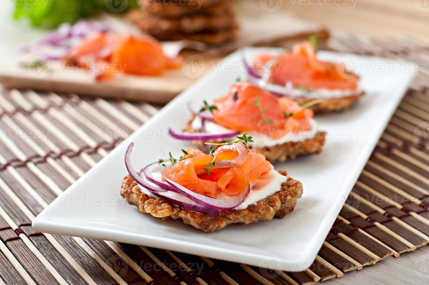 Buckwheat pancakes with salted salmon and sour cream close up photo