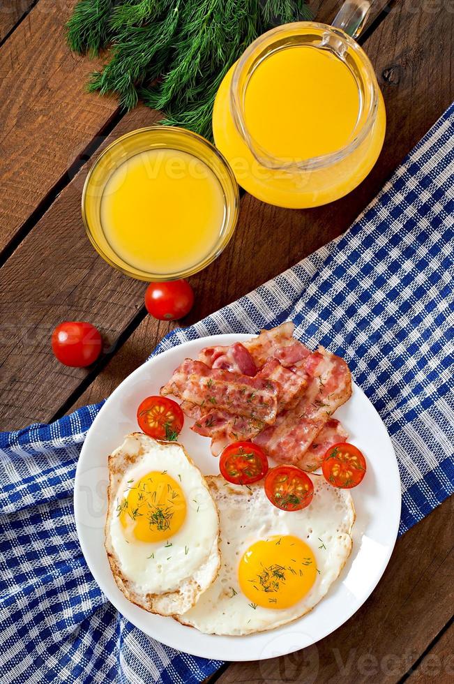 English breakfast - toast, egg, bacon and vegetables in a rustic style on wooden background photo