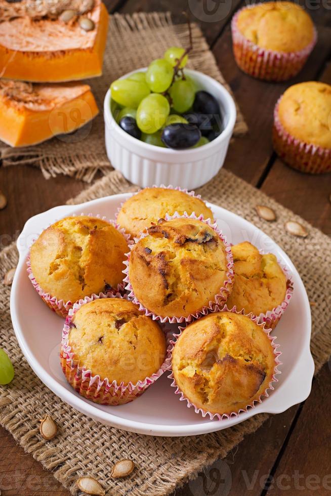 Appetizing and ruddy muffins with pumpkin and grapes photo
