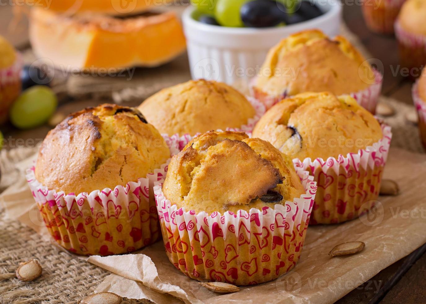Appetizing and ruddy muffins with pumpkin and grapes photo