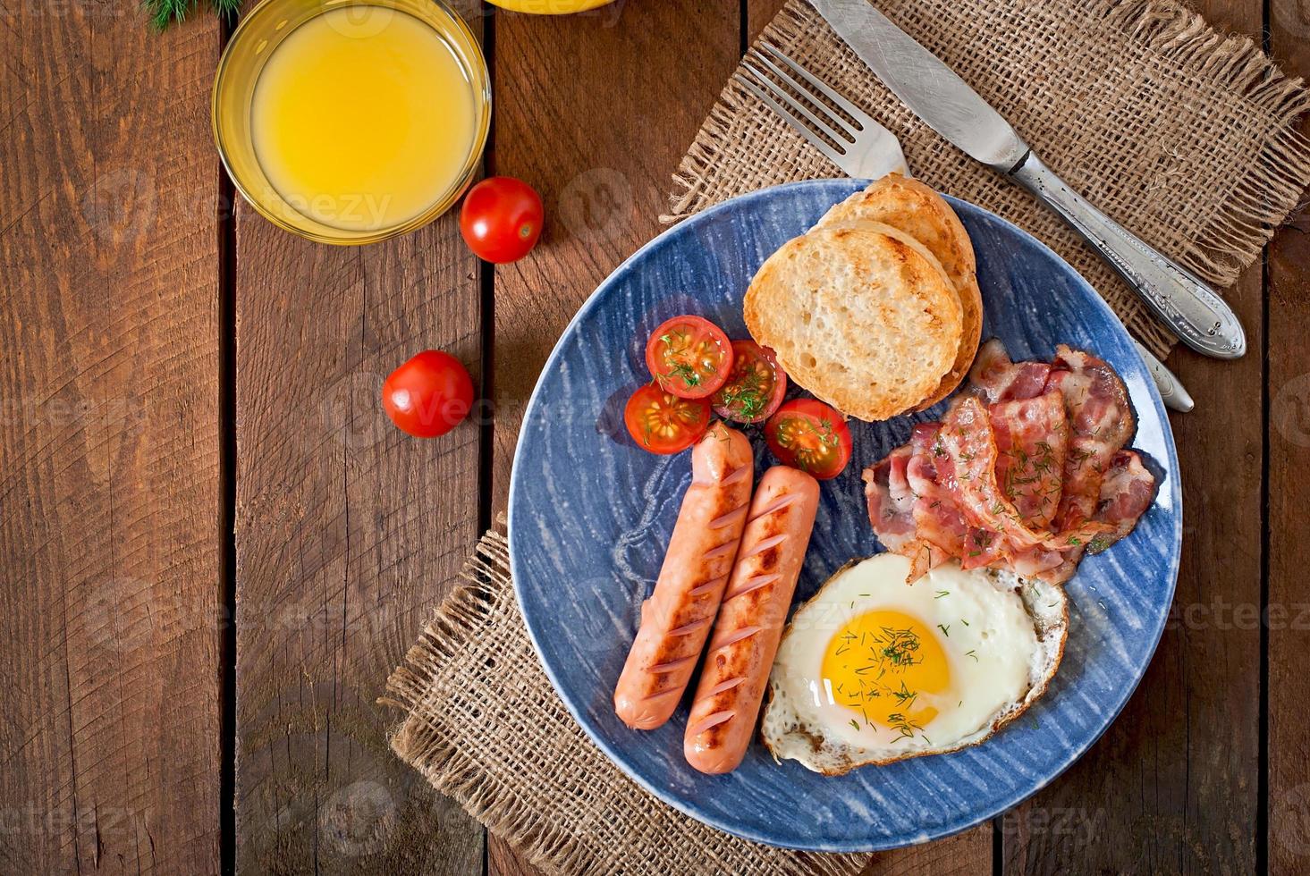 English breakfast - toast, egg, bacon and vegetables in a rustic style on wooden background photo