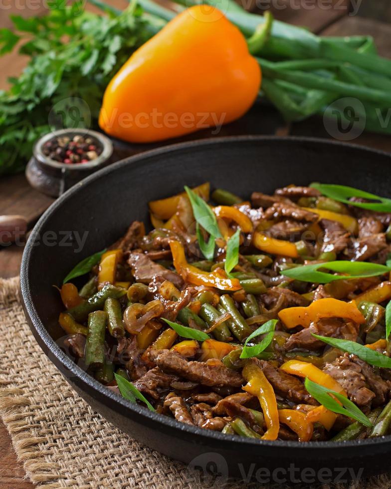 Stir frying beef with sweet peppers and green beans photo